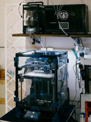 A modern 3D printer setup in a technology workshop with various tools and devices.